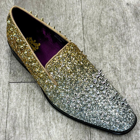 A single Exclusive Formal Dress Shoe Gold / Silver 6860, featuring a glittery gradient design from gold to silver and adorned with metallic spikes, crafted from genuine leather by UNIQUE DESIGN MENSWEAR. It is displayed on a textured gray surface, reflecting the elegance of Italian craftsmanship.