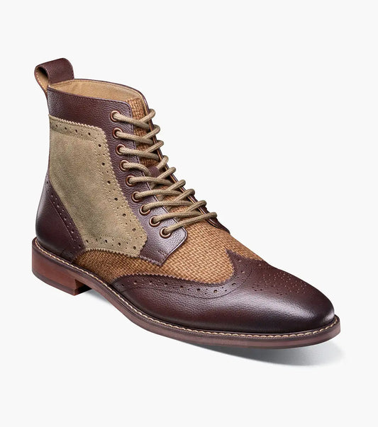 The Stacy Adams Finnegan Wingtip Lace Up Boot in Brown Tumbled (style 25427-247) features brown and tan leather suede, brogue wingtip detailing, a lace-up closure, a memory foam insole for added comfort, and a low heel, shown against a white background.