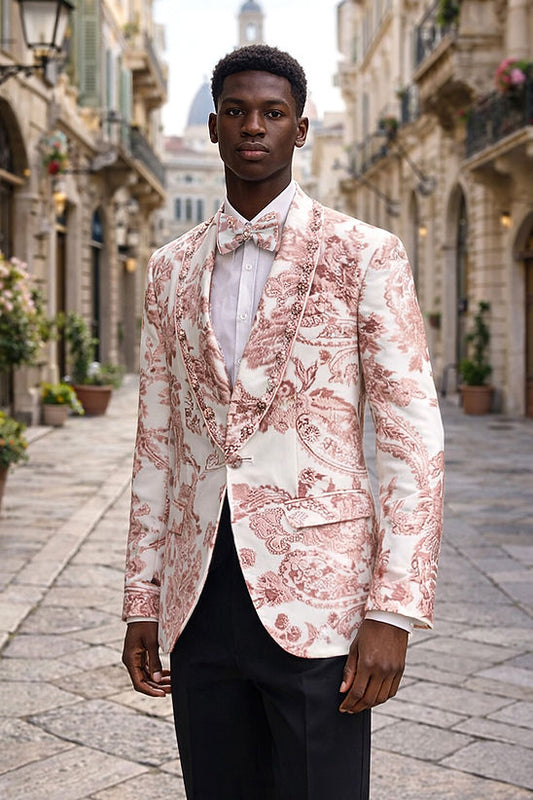 A man in a Manzini MZS-602 Men's Rhinestone Shiny Metallic Floral Tuxedo Prom Jacket in Rose Gold stands on a cobblestone street lined with historic buildings.