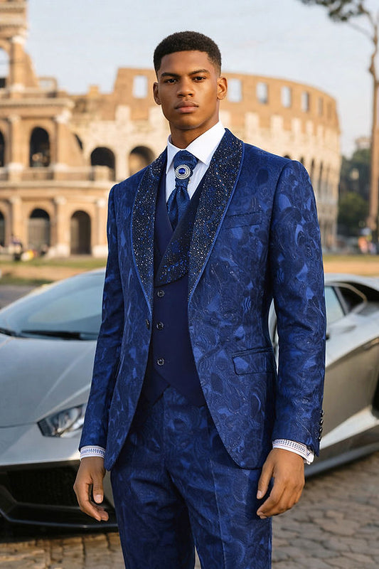 A man wears the Manzini TOWER 3-Piece Slim-Fit Vintage Tuxedo Prom Wedding Suit with Rhinestones in blue, standing before a sports car and Roman-style building, looking directly at the camera.