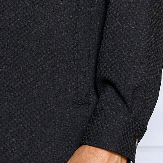 A man with short hair and a beard stands against a white decorative wall, wearing the Insomnia INSOMNIA ROBERTO 2PC Black Leisure Suit made from a soft poly rayon blend.