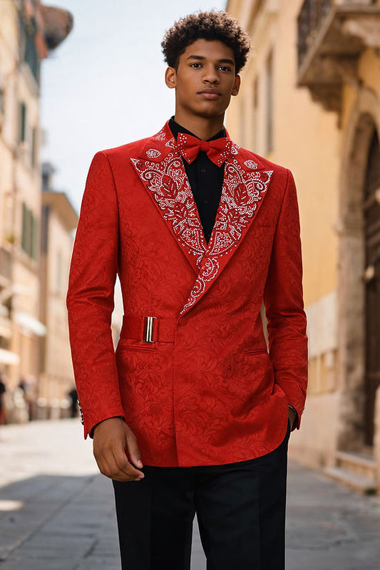 A man stands outdoors on a sunlit street, wearing the MANZINI MZS-607 Men's Double Breast Slim-Fit Coat in shiny red with rhinestone floral pattern by Manzini, paired with a bow tie, black shirt, and black pants.