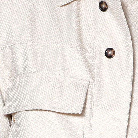 A man with short hair and a beard wears the INSOMNIA FENDI 2PC Tan Leisure Suit by Insomnia, featuring large front pockets, standing against a light-paneled background.