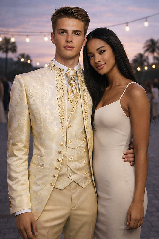 A young man in a Manzini Lanzini 3-Piece Slim-Fit Baroque Gothic Tuxedo with rhinestones in champagne stands beside a woman in a beige dress; both pose outdoors at an evening event with glowing string lights.