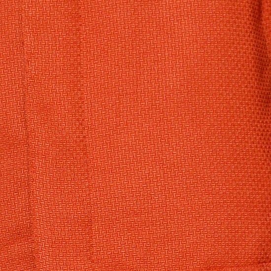 A man wearing the INSOMNIA CAVALLI 2PC Coral Leisure Suit by Insomnia, featuring a textured button-up shirt with chest pockets and matching pants, stands against a light-colored paneled wall.