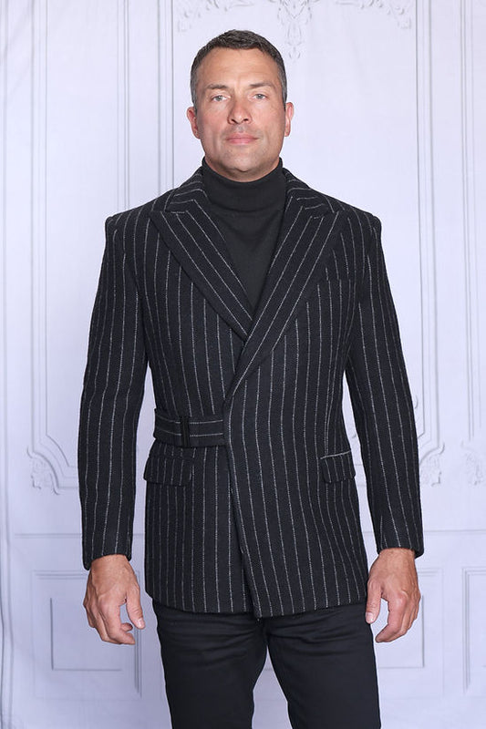 A man wears the Manzini MZW-703 Men's Wool Feel Pinstripe Blazer Coat with Hook Belt in black, standing against a light background and looking slightly to the side.