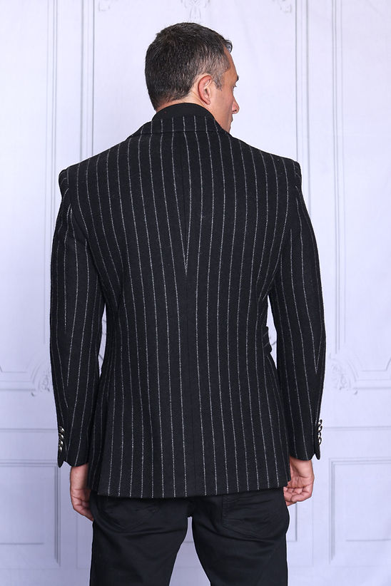 A man wears the Manzini MZW-703 Men's Wool Feel Pinstripe Blazer Coat with Hook Belt in black, standing against a light background and looking slightly to the side.