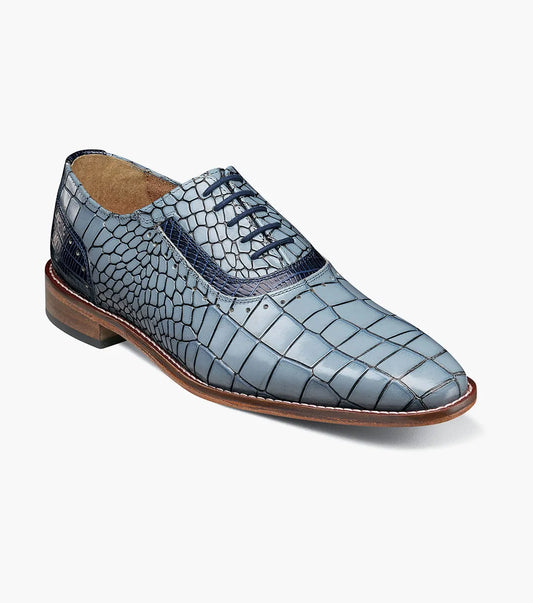 The Stacy Adams Riccardi Plain Toe Oxford in Light Blue Multi features croco and lizard print leather, a leather sole, anatomical arch support, and dark blue laces. Only one shoe is shown against a white background.