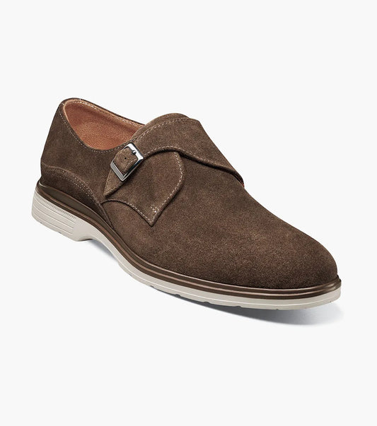 The STACY ADAMS Taylen Plain Toe Monk Strap (Brown Suede, 25589-245) features men's suede leather, a single side buckle, anatomical arch support, low heel, and a light rubber sole, displayed on a white background.