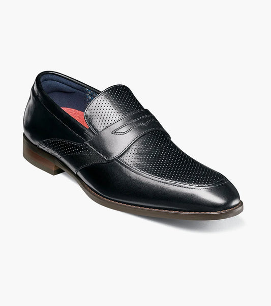 The STACY ADAMS Karnes Moc Toe Penny Slip On in black (25591-001) features an orthotic insole with a molded heel cup, anatomical arch support, cushioned heel pod, and durable rubber outsole. Displayed on a white background with labeled features.
