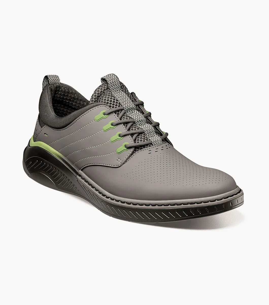 The Stacy Adams Barna Plain Toe Lace Up sneaker in gray (25594-020) features black and green accents, patterned laces, a perforated toe, removable footbed, and a textured black sole; displayed on a white background.