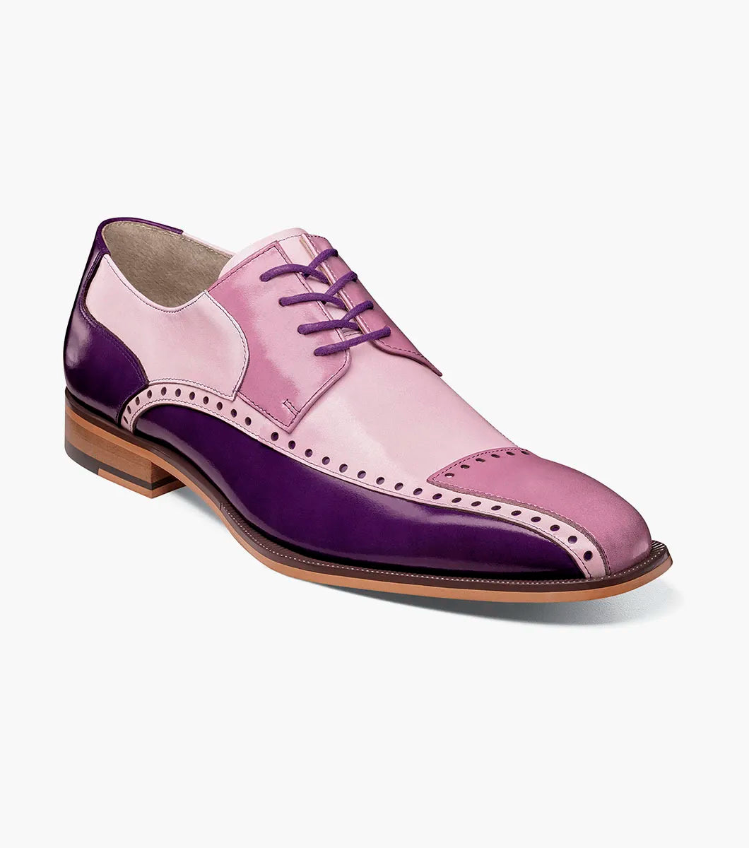 The STACY ADAMS Plaza Modified Cap Toe Oxford (25608-540) is a men's dress shoe featuring a pointed toe, leather upper in purple and pink gradient, decorative perforations, and a light brown sole.