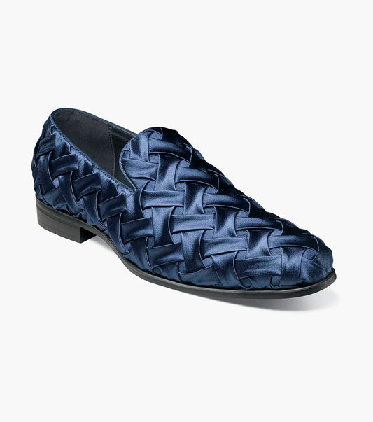 The STACY ADAMS Savoir Plain Toe Satin Slip On (Navy, 25611-410) is a men's loafer with a glossy woven satin design, low black heel, and memory foam insole, shown on a white background.