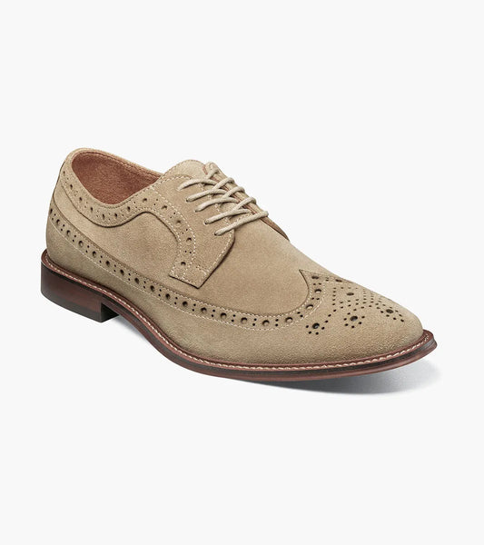 The Stacy Adams Marligan Wingtip Oxford (Sand, 25616-269) is a tan suede leather dress shoe with brogue detail, laces, and a dark brown sole by STACY ADAMS, shown on a white background.