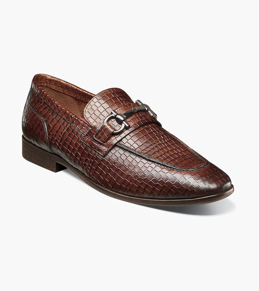 The Stacy Adams Feronte Moc Toe Bit Slip On in Cognac (25623-221) is a men's brown woven leather loafer with a metal bit, low heel, and almond toe, shown against a white background.