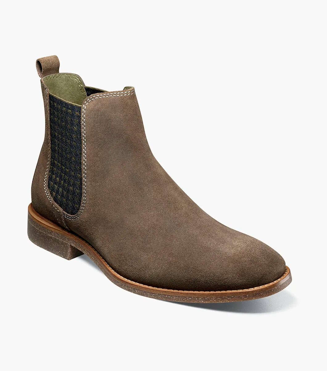 The STACY ADAMS Gabriel Plain Toe Chelsea Boot in Mushroom (25625-051) features a brown suede upper, side elastic panel, back pull tab, low heel, and cushioned RedZone footbed, displayed on a plain white background.