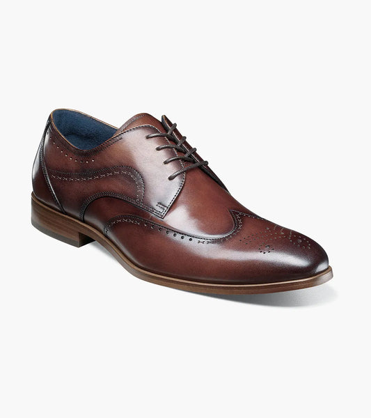 The STACY ADAMS Brayden Wingtip Oxford in brown (25635-200) features burnished leather, decorative perforations, laces, and a low wooden heel, shown on a white background.