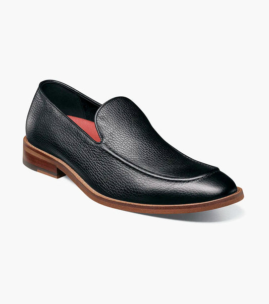 The Stacy Adams Prentice Moc Toe Slip On (25649-007) features black tumbled leather, a textured finish, brown wooden heel, and thin brown sole; shown on a white background.