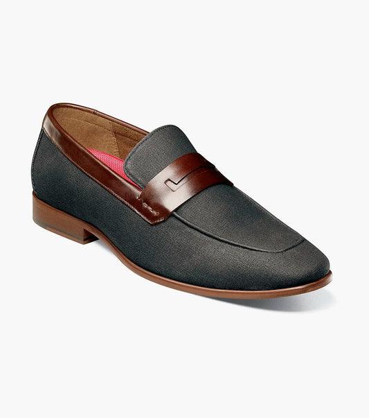 The STACY ADAMS Gill Moc Toe Saddle Slip On (25651-009) is a black multi men’s loafer with a leather upper accent, low heel, RedZone footbed, and rounded toe, shown on a white background.