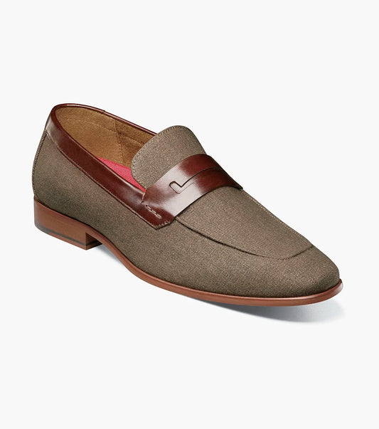 The Stacy Adams Gill Moc Toe Saddle Slip On in Mushroom Multi features a brown fabric upper, smooth leather strap and trim, low wooden heel, and moc toe design by STACY ADAMS. Product code: 25651-053. Displayed on a plain white background.