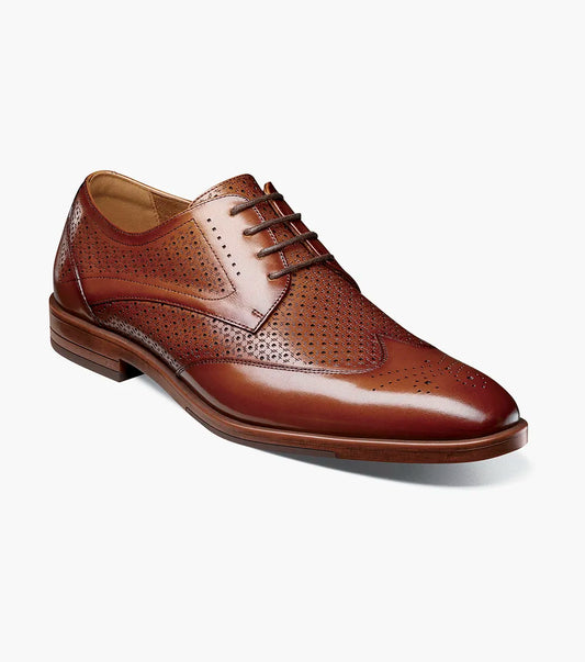 The Stacy Adams Asher Wingtip Lace Up in Cognac (25653-221) is a genuine leather dress shoe with brogue perforations, anatomical arch support, and a low heel by STACY ADAMS, shown on a plain white background.