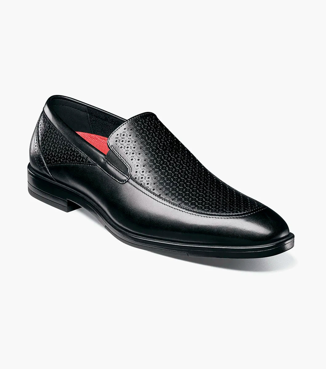 The Stacy Adams Aiden Moc Toe Slip On (25655-001) in black features a genuine leather upper with textured perforation, anatomical arch support, and a low heel. Displayed on a white background.