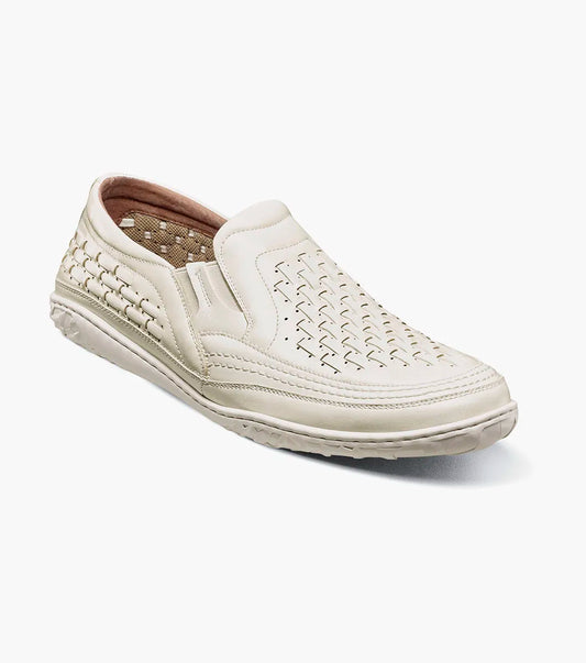 The Stacy Adams Ithaca Moc Toe Slip On in white features woven detailing, a textured sole, elastic side panels for easy wear, and a cushioned memory foam footbed for comfort.