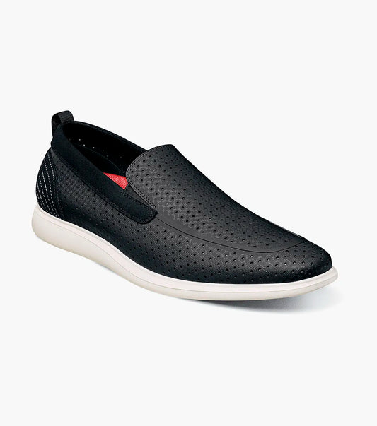 The Stacy Adams Remy Moc Toe Perf Slip On (Black, 25658-001) features black perforated leather, white sole, red inner lining, and an odor-eliminating footbed, shown on a plain light background.