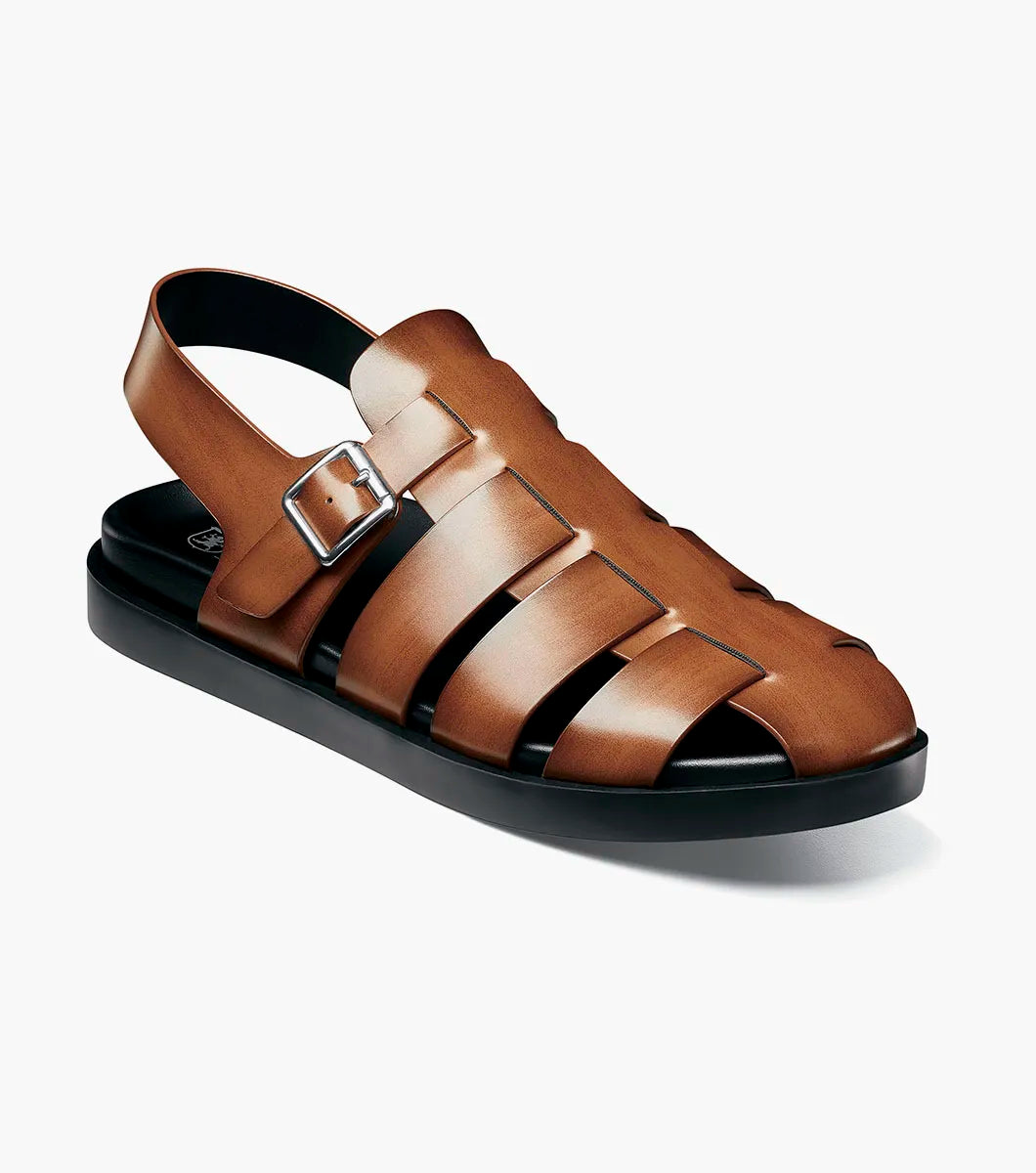 The STACY ADAMS Montego Slingback Buckle Sandal in Cognac (25659-221) features brown leather, a burnished finish, silver buckle, and black sole with EVA midsole, shown in side profile on a plain white background.