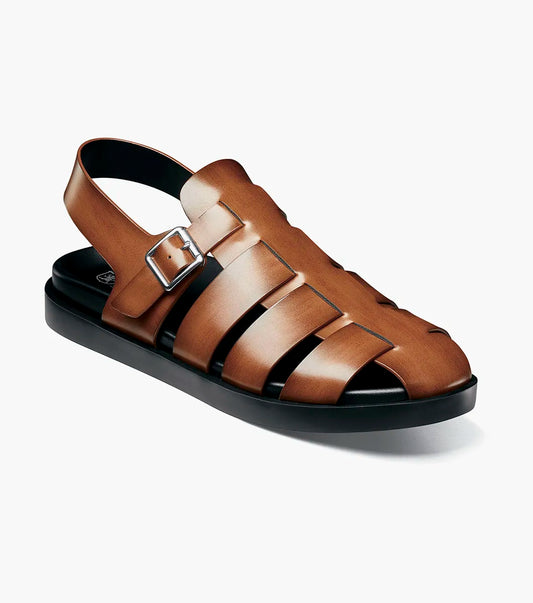 The STACY ADAMS Montego Slingback Buckle Sandal in Cognac (25659-221) features brown leather, a burnished finish, silver buckle, and black sole with EVA midsole, shown in side profile on a plain white background.