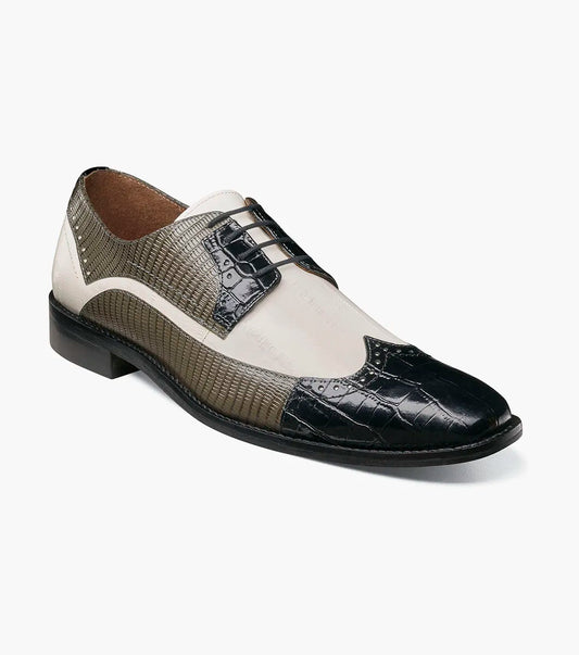 The Stacy Adams Gallinari Wingtip Lace Up (25660-910) is a men’s leather dress shoe in black and grey with off-white panels, textured pattern, cushioned footbed, and lace-up closure, shown on a white background.
