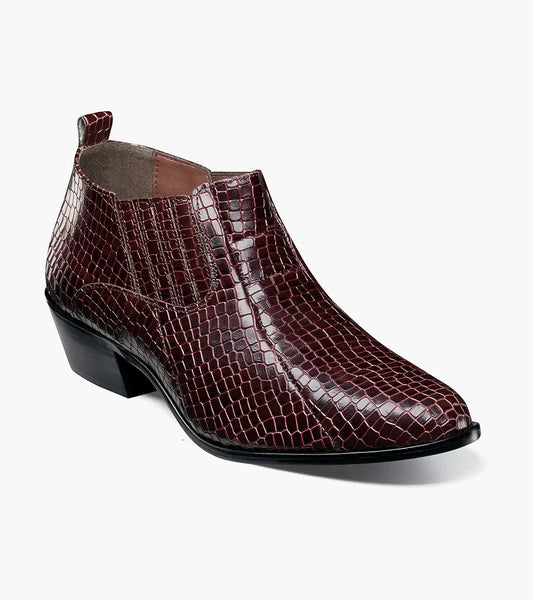 The STACY ADAMS Sandoval Cuban Heeled Boot in Burgundy (25666-601) is a single maroon ankle boot with a low Cuban heel, shiny crocodile print texture, side stretch panels, and a cushioned footbed for comfort.