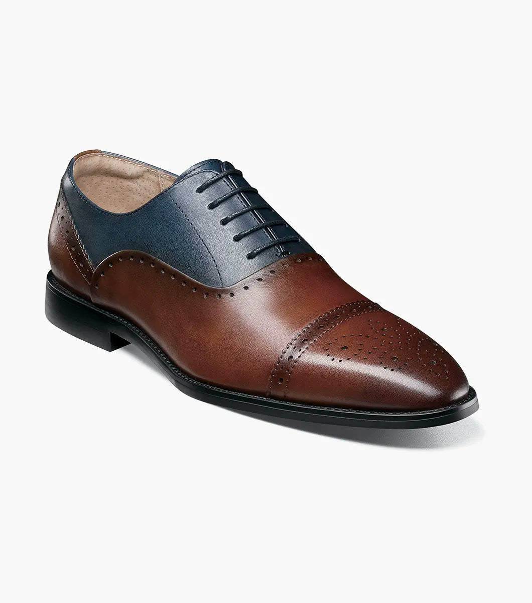 The Stacy Adams Reynolds Cap Toe Oxford (25670-989) features brown and navy leather, perforated detailing, closed lacing, a memory foam insole, and a low black heel.