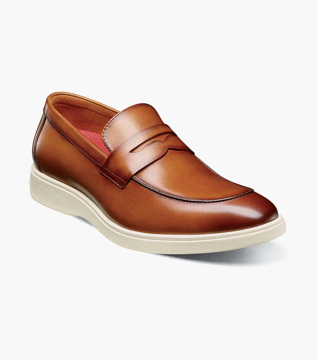 The Stacy Adams Spencer Moc Toe Penny Slip On (Tan, style 25673-240) is a men's dress shoe with a classic loafer design, white rubber sole, and brown leather upper, shown on a plain white background.