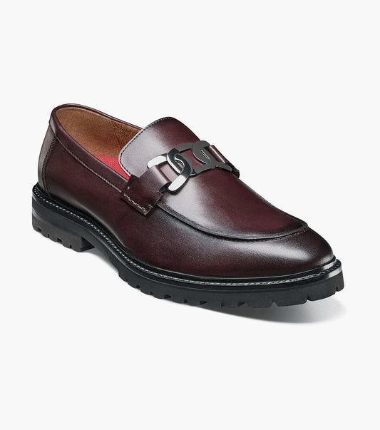 The STACY ADAMS Hale Moc Toe Bit Slip On in Bordeaux (25678-646) is a burgundy leather slip-on loafer with a black rubber sole, anatomical arch support, and metal bit detail on the upper.