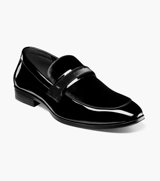 The STACY ADAMS Spratley Moc Toe Saddle Slip On in black features patent leather, a low heel, velvety strap detail, memory foam cushioning, and a slightly pointed toe, shown on a white background.