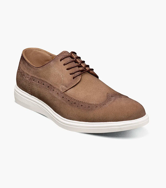 The Stacy Adams Trudell Wingtip Lace Up in sand suede features decorative stitching and a white rubber sole, shown in a side view against a plain background. Model: 25691-269.