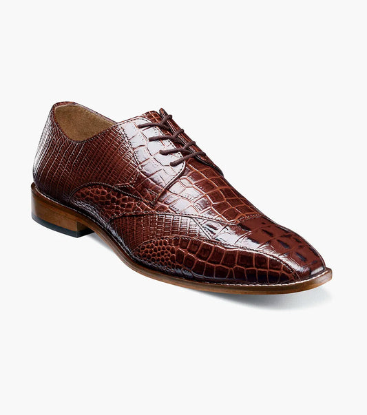 The Stacy Adams Tristano Modified Bike Toe Oxford in cognac features a brown crocodile print leather upper, laces, low wooden heel, genuine leather outsole, and pointed toe by STACY ADAMS, displayed on a plain light background.