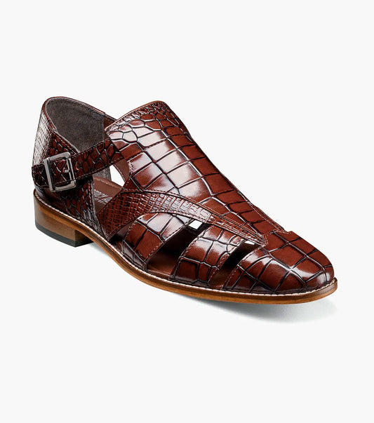 The STACY ADAMS Calandro City Sandal (Cognac, 25695-221) is a brown genuine leather dress shoe with a crocodile pattern, cushioned footbed, side buckle, and closed toe, displayed on a white background.