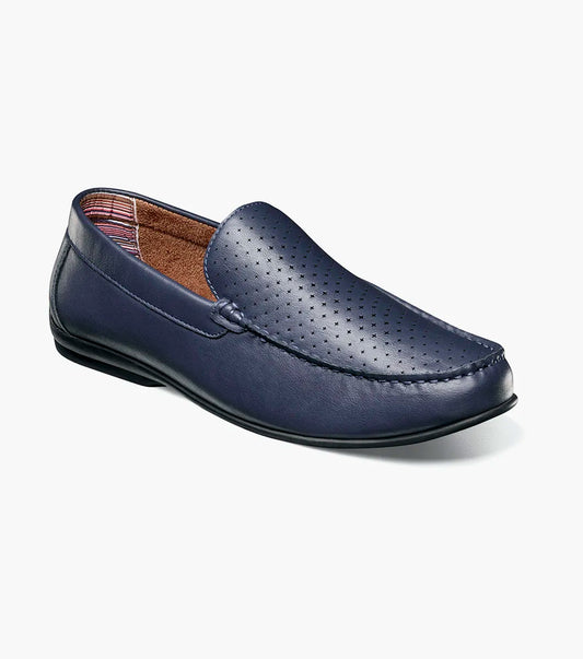 The STACY ADAMS Conroy Moc Toe Perf Slip On (Navy, 25702-410) features a perforated leather upper, cushioned footbed, and black sole, shown in side profile against a plain white background.