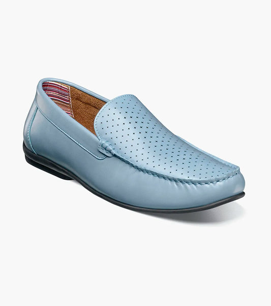 The STACY ADAMS Conroy Moc Toe Perf Slip On (25702-459) features light blue leather, perforated detailing, black sole, visible stitching, and a cushioned footbed, shown in side profile against a white background.