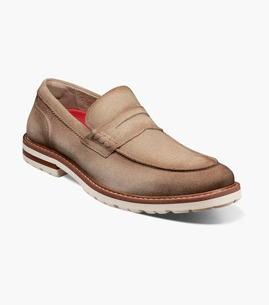 The STACY ADAMS Hopkins Moc Toe Penny Slip On in Sand (25708-269) is a light brown suede loafer with a white and tan rubber sole and red interior lining, shown on a white background.