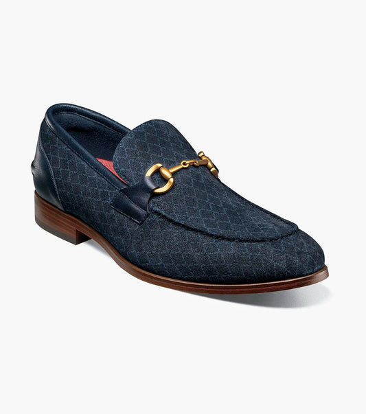 The STACY ADAMS Brinkley Moc Toe Bit Slip On (Navy, 25711-410) features a dark blue suede upper, gold horsebit detail, leather trim, and wooden sole, displayed against a plain white background.