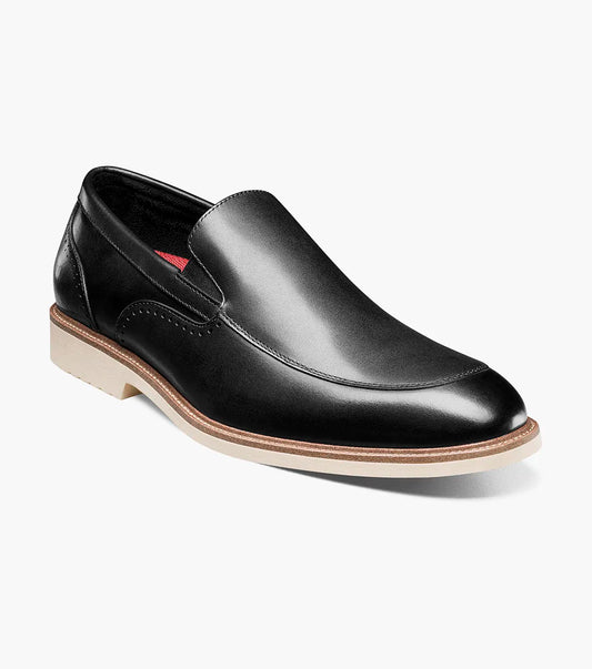 The STACY ADAMS Wellington Moc Toe Slip On (25714-001) is a black leather dress shoe featuring Memory Foam cushioning and a light brown sole, shown against a plain white background.