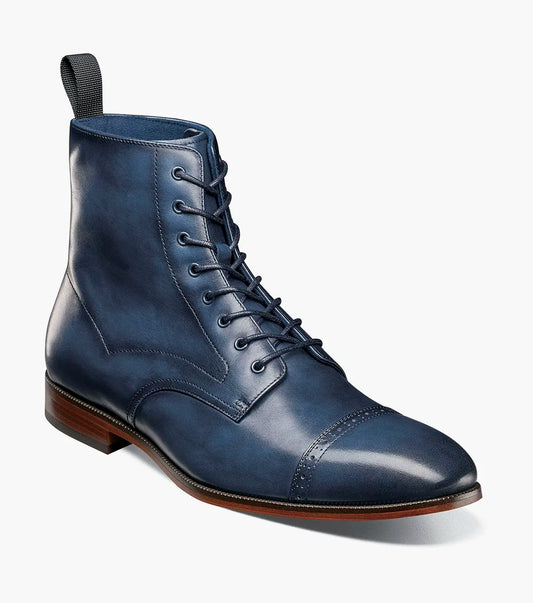 The Stacy Adams Henry Cap Toe Lace Up Boot (Navy, 25718-410) features a dark blue leather upper, cap toe, brown sole, and black heel tab. Shown in side profile on a white background.