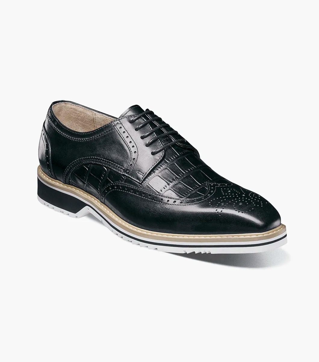 The Stacy Adams Beaumont Wingtip Oxford in black (25723-001) features brogue detailing, lace-up closure, soft leather linings for comfort, and a contrasting white sole by STACY ADAMS, displayed on a plain white background.