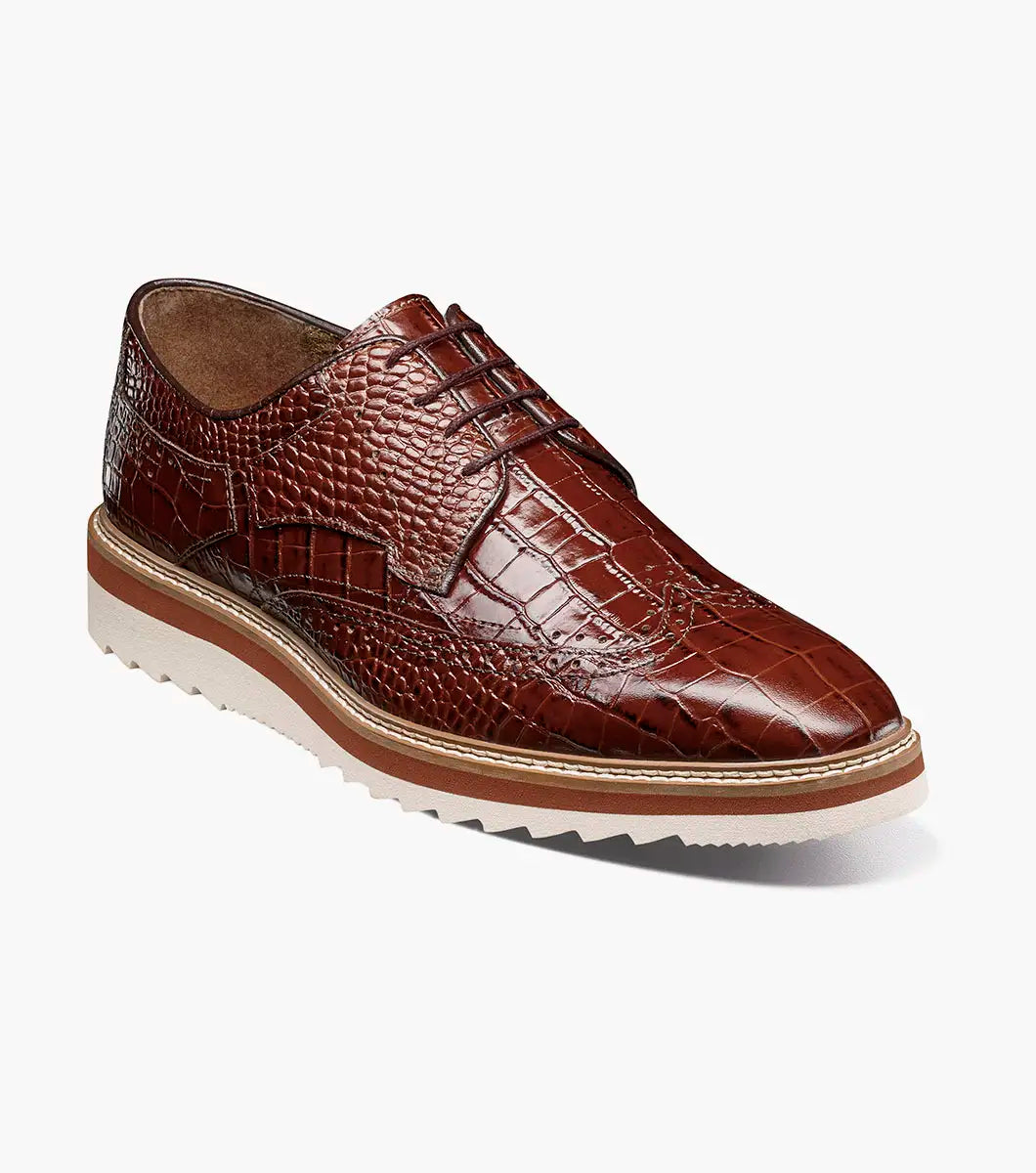 The STACY ADAMS Alario Wingtip Oxford in Cognac (25725-221) features a crocodile print leather upper, thick white and tan sole, lace-up design, and textured finish.