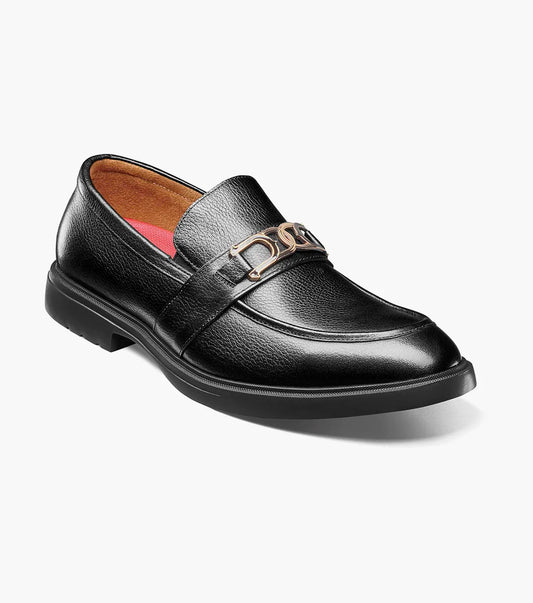 The Stacy Adams Todridge Moc Toe Bit Slip On in black tumbled leather features a gold metal accent, cushioned footbed, tan lining, and black rubber sole.
