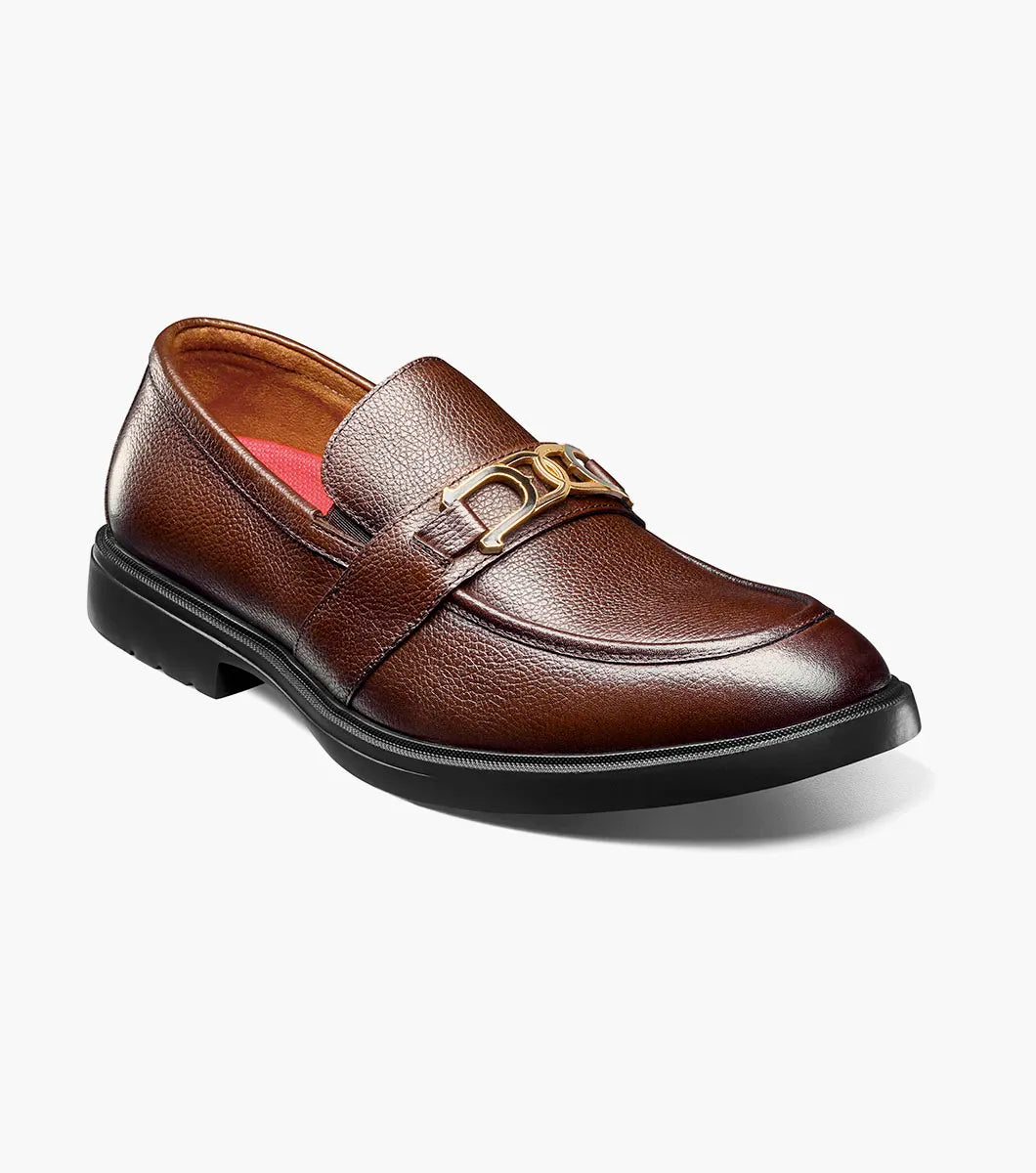 The Stacy Adams Todridge Moc Toe Bit Slip On in Brown Tumbled features a gold metal accent, black rubber sole, visible stitching, and a cushioned footbed for all-day comfort. Style: 25729-247.