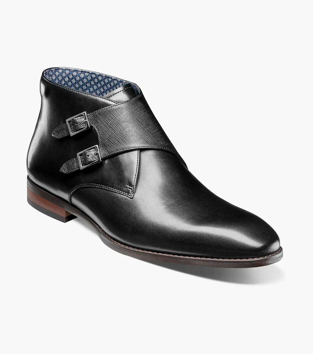 The STACY ADAMS Kaius Plain Toe Double Monk Strap Boot (25733-001) features a black leather upper, silver buckles, low stacked heel, anatomical arch support, and a patterned inner lining.